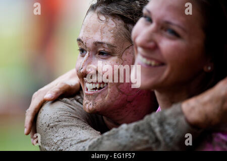 Trisha Loede, left, hugs Ann Mitchell after completing the Women's History Month Ultimate Dirty Dash at Incirlik Air Base, Turkey, March 31, 2012. Seventy-five teams participated in the event, which gave members of the base a chance to compete in physical activities while answering women's history trivia questions. Loede is with the 39th Air Base Wing and Mitchell is with the 39th Force Support Squadron.  Senior Airman Clayton Lenhardt Stock Photo