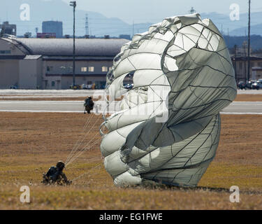 Pararescuemen from the 31st Rescue Squadron touch down in a landing zone at Yokota Air Base, Japan, Jan. 7, 2015 during ‘Jump Week’. During Jump Week, members of the 31st RQS link up with the 36th AS to maintain mission readiness and rescue tactics in preparation for real-world emergencies.  Osakabe Yasuo Stock Photo