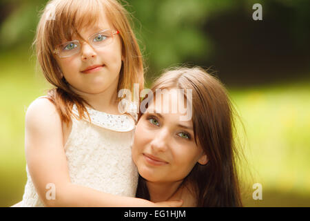 Happy family. Little girl daughter kid child hugging his mother expressing tender feelings. Love. Stock Photo