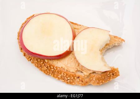 Peanut butter and apple open face sandwich with a bite taken Stock Photo