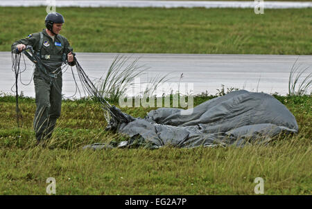 Staff Sgt. Daniel Guy, 736th Security Forces Squadron fire team leader, collects his parachute Aug. 21, 2013 after a static line jump over the Andersen Air Force Base, Guam, flight line. As the integrated force protection element of the 36th Contingency Response Group, members of the 736th SFS provide a quick-response airborne capability that serves as an advance echelon team for contingency and humanitarian missions all over the Asia-Pacific region.  Airman 1st Class Marianique Santos Stock Photo