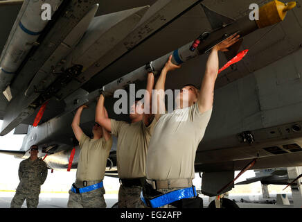A weapons load team from the 44th Aircraft Maintenance Unit loads an ...