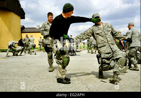 Ken Good, a former Navy SEAL, instructs Security Forces Squadron Airmen and law enforcement members how to defend themselves when someone is trying to take their weapon during Progressive Combat Solutions training at  Scott Air Force Base, Ill., April 8, 2014. The Progressive Combat Solutions trains military and law enforcement personnel in a decision making process originally benchmarked by the Air Force known as observe, orient, decide and act. The Air Mobility Command and the 375th Security Force Squadron hosted this training with the goal of implementing it across the AMC command in the fu Stock Photo