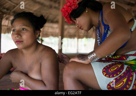 Women native embera doing a tattoo in the Village of the Indian Embera Tribe, Embera Village, Panama. Panama Embera people India Stock Photo