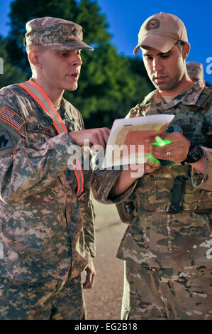 U.S. Army Spc. Justin Jackson, Alpha Company, 179, and U.S. Air Force Tech. Sgt. Larry Mansell, exchange information at a checkpoint during the night in Moore, Okla., May 22, 2013. Checkpoints have been set up all over the city to ensure residents safety and security after the devastating tornado that struck on May 20, 2013.  by Staff Sgt. Caroline Hayworth Stock Photo