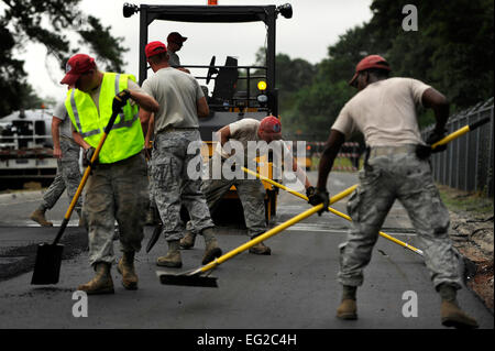 Airmen assigned to the 823rd RED HORSE Squadron, sweep, shovel and rake as they perfect freshly laid asphalt on Aiken Street, at Shaw Air Force Base, S.C., July 12, 2012. A team of 21 Airmen is slated to repave just over a mile of Shaw roadway. The 823rd RHS is an Air Combat Command asset assigned to the Ninth Air Force that operates out of Hurlburt Field, Fla. RED HORSE stands for Rapid Engineer Deployable Heavy Operational Repair Squadron Engineer.  Senior Airman Kenny Holston Stock Photo