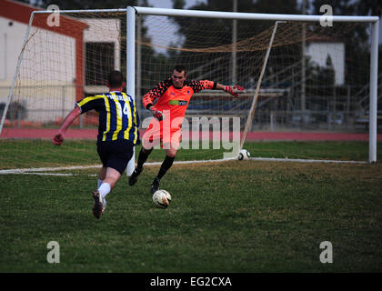 Senior Airman Scott Decker, 39th Operations Squadron air traffic controller, kicks a ball as 2nd Lt. Jop Van Der Spek, 802 Patriot tactical control officer defends the goal during the NATO soccer tournament Nov., 8, 2013, at Incirlik Air Base, Turkey. Van Der Spek spends his free time on his deployment to Incirlik AB honing his skills for his goalie position on the base team.  Airman 1st Class Nicole Sikorski Stock Photo