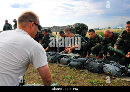 Master Sgt. Stephen Nelson, 435th Contingency Response Group contingency air traffic controller, instructs Bulgarian paratroopers on the correct way to use a standard U.S. parachute during a flying training deployment, July 17, 2013, in Plovdiv, Bulgaria. American and Bulgarian paratroopers exchanged parachutes for the opportunity to conduct a wing exchange at the end of FTD Thracian Summer.  Airman 1st Class Trevor Rhynes Stock Photo