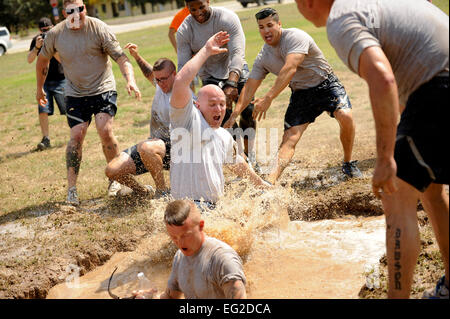 Members of the 39th Security Forces Squadron jump into the mud pit during the 39th Air Base Wing Sports Day tug-of-war event at Incirlik Air Base, Turkey, June 1, 2012. Airmen from several squadrons competed in friendly games of volleyball, softball, basketball, kickball, dodgeball and tug-of-war.  Senior Airman Jarvie Z. Wallace Stock Photo