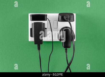 Battery chargers plugged in to outlet Stock Photo