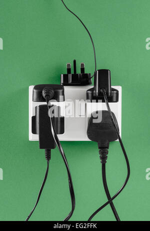 Multiple Chargers plugged in to Wall Socket Stock Photo