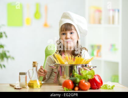 Child makes healthy vegetables meal in the kitchen Stock Photo