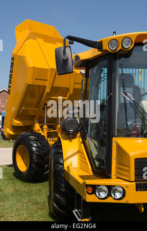 Under deep blue sky, a clean, bright yellow Hydrema 922D dump truck is parked & displayed on a trade stand - Great Yorkshire Show, England, UK. Stock Photo