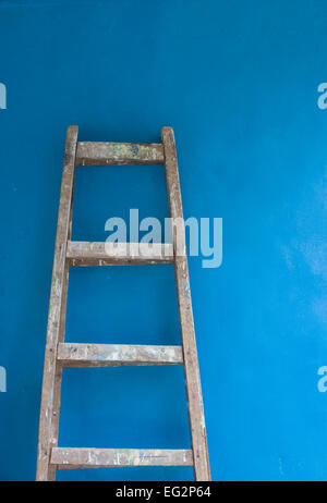 Lladder against blue wall Stock Photo