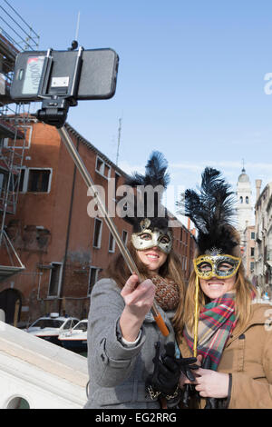 Carnival at Venice, Veneto, Italy. Two women take a selfie with the help of a selfie stick. Stock Photo