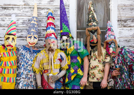 Wearing traditional Cajun Mardi Gras costumes and mask participants pose for portrait during the Courir de Mardi Gras February 14, 2015 in Elton, Louisiana. Revelers go from house to house begging to gather food for a communal meal and celebrate by dancing for bystanders when successful. Capitaines riding horseback try to control the good natured revelers as they romp through the countryside causing mischief. Stock Photo