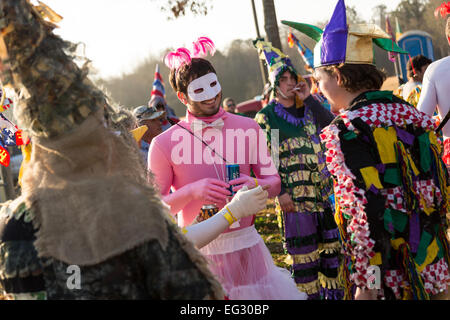 Wearing traditional Cajun Mardi Gras costume and mask runners prepare for the start of the Courir de Mardi Gras February 14, 2015 in Elton, Louisiana. Revelers go from house to house begging to gather food for a communal meal and celebrate by dancing for bystanders when successful. Capitaines riding horseback try to control the good natured revelers as they romp through the countryside causing mischief. Stock Photo