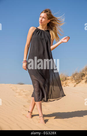 Woman in long black dress on the beach Model released Stock Photo