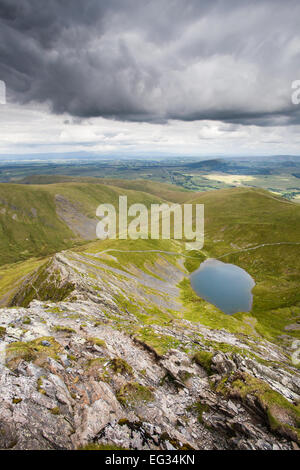 The dramatic, rocky spine of Sharp Edge and down on Scales Tarn on the ascent of Blencathra, a mountain in the Lake District Stock Photo