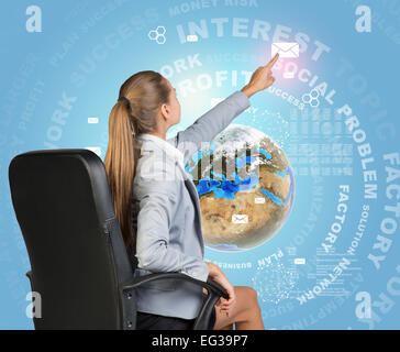 Businesswoman pressing envelope icon on virtual interface Stock Photo