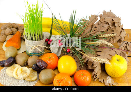 Rich Christmas Eve offerings including various dried and fresh fruit, green wheat and walnuts on a wooden table, isolated, Stock Photo