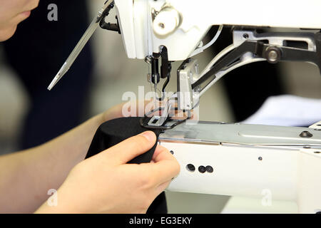 Seamstress sews material on the sewing machine Stock Photo