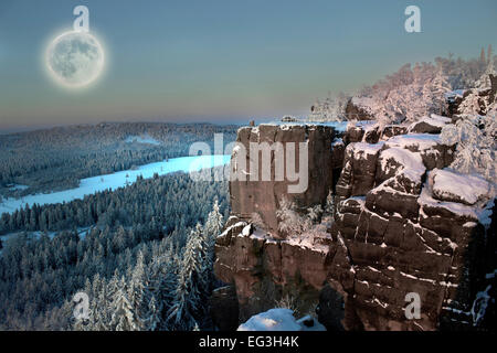 Full moon up the mountain forest in morning snow. Stock Photo