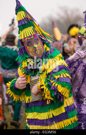 Revelers wearing traditional Cajun Mardi Gras masks and costumes dance for food during a begging run at the Courir de Mardi Gras chicken run February 15, 2015 in Church Point, Louisiana. The event involves 900-hundred costumed revelers competing to catch a live chicken as they move from house to house throughout the rural community. Stock Photo