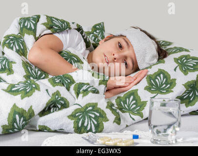 Sick boy lying in bed with high fever Stock Photo