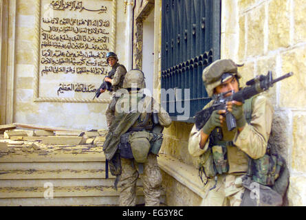 US MARINE CORPS Marines from the 1st Battalion, 7th Marines (1/7), Charlie Company, Twentynine Palms, California (CA), cover each other with 5.56 mm M16A2 assault rifles as they prepare to enter one of Saddam Hussein’s palaces in Baghdad as they takeover the complex during Operation IRAQI FREEDOM in April 2003. Stock Photo