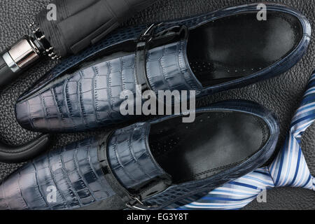 Classic blue men's shoes, tie, umbrella on the black leather, can be used as background Stock Photo