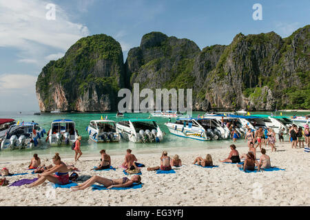 Tourist boats and tourists in Maya Bay on Koh Phi Phi Ley island in Thailand.