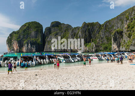 Tourist boats and tourists in Maya Bay on Koh Phi Phi Ley island in Thailand.