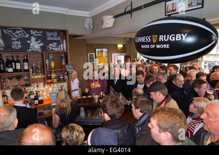 Rugby fan fans wait for barman man barmaid / staff at busy The Albany pub / public house. Twickenham UK; popular match days. Stock Photo