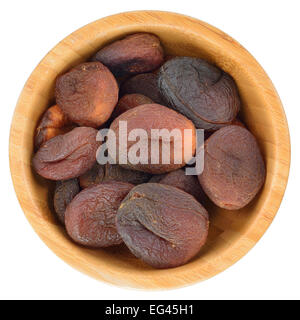 Sun dried apricots in wooden bowl isolated on white background. Stock Photo