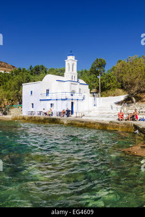 People along the shore next to the small whitewashed church of Ayios Markos at Stavros beach on Tinos Island, Cyclades, Greece Stock Photo