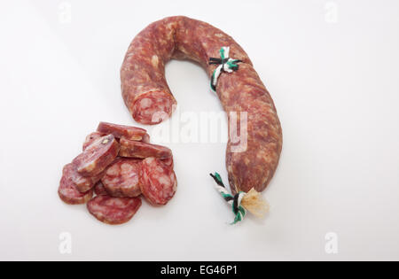 Cured spicy sausage with some cut pieces. Isolated over with background Stock Photo