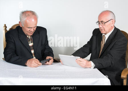 two senior businessmen,  using tablet and smatphone Stock Photo