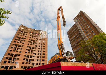 A demolition crane sits in front of a partially demolished tower block at Ibrox, near Govan in the south west of Glasgow. Stock Photo