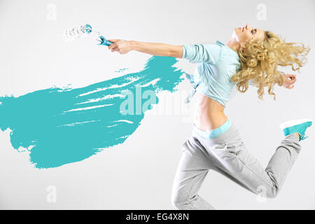 Fit lady painting empty walls Stock Photo