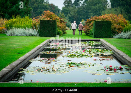 Visitors in formal garden with lily pond. Waterperry Gardens Stock Photo