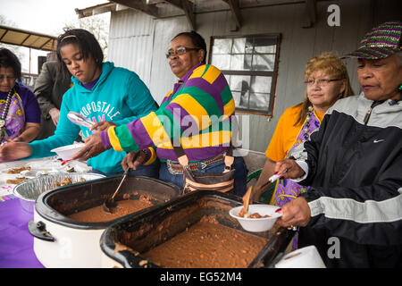 A family dishes out homemade food for revelers during a stop at the Creole Courir de Mardi Gras chicken run February 16, 2015 in Soileau, Louisiana. The traditional rural Mardi Gras event evolved from the exclusion by white communities of black and indian residents from the larger local celebrations. Stock Photo