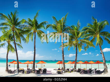 white beach lounge bar chairs and umbrellas on boracay tropical island in philippines Stock Photo