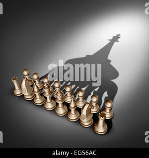 Company leadership and team management vision as a business group concept with chess set pieces joining and working together united and as one in agreement to cast a shadow shaped as  a king leader. Stock Photo