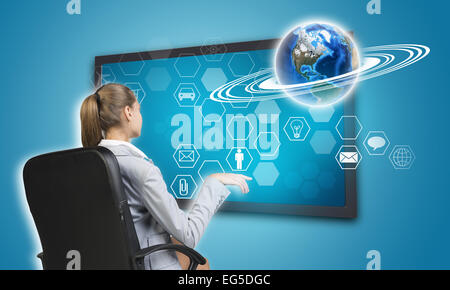 Businesswoman pressing touch screen button on virtual interface Stock Photo