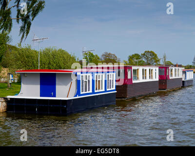 Wooden houseboats moored at Hickling Staithe in the Norfolk Broads an area of inland waterways in East Anglia Eastern England UK Stock Photo