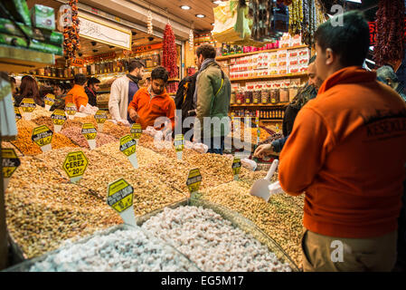Spice Bazaar Nuts And Grains Store Istanbul | ISTANBUL, Turkey — A store selling nuts and grains at the Spice Bazaar (Mısır Çarşısı, also known as the Egyptian Bazaar) in Istanbul's Eminönü district. The bazaar is one of the city's largest and oldest covered markets, constructed in the early 1660s as the income-generating arasta of the New Mosque külliye endowed by Valide Sultan Turhan Hatice Sultan. Its roughly 88 historic vaulted shop units were originally occupied largely by herbalist-apothecaries (aktarlar) and merchants trading in cotton and quilts, before spices, dried fruits, nuts, and  Stock Photo
