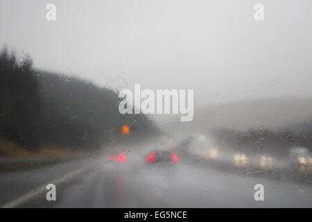 Difficult driving conditions - view through rain on windscreen - UK motorway Stock Photo