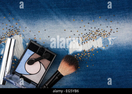 Still life from cosmetics on ragged jeans with rhinestones, with place for your text Stock Photo