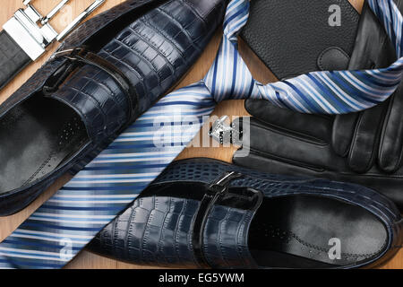 Classic men's shoes, tie, cufflinks, gloves, belt, purse on the wooden floor, can be used as background Stock Photo